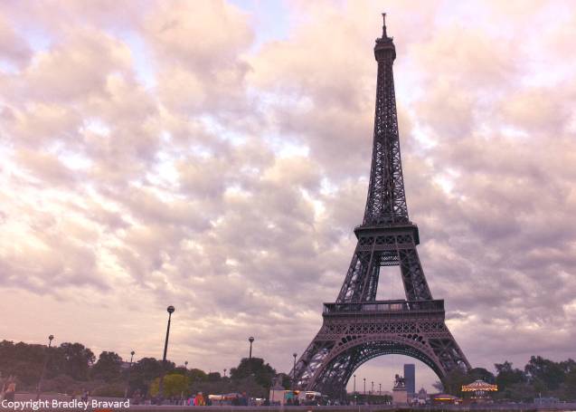 Eiffel Tower in Paris with scattered clouds in sky