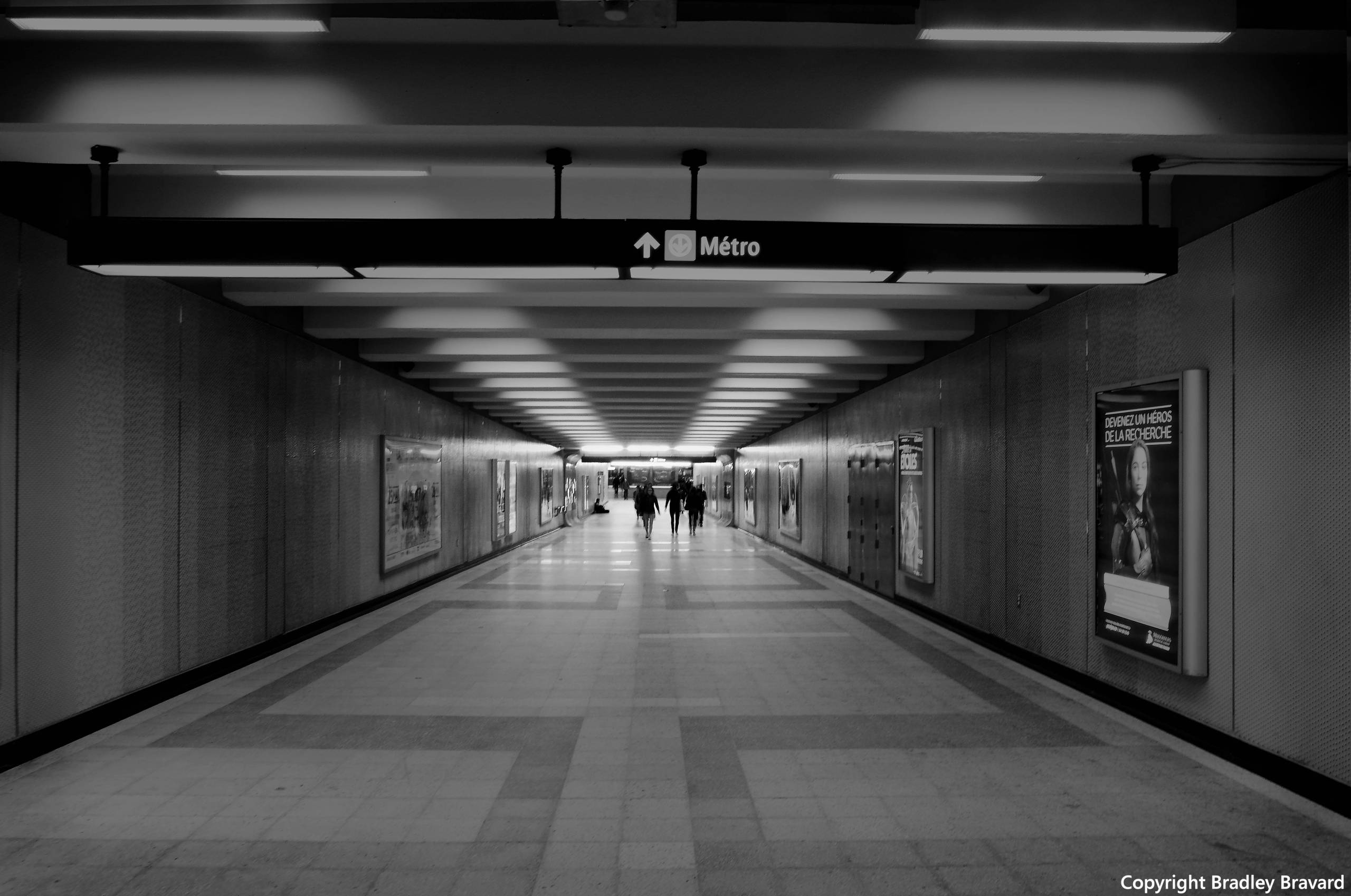 Black and white photo of a group of people at the far end of a Montreal Metro tunnel
