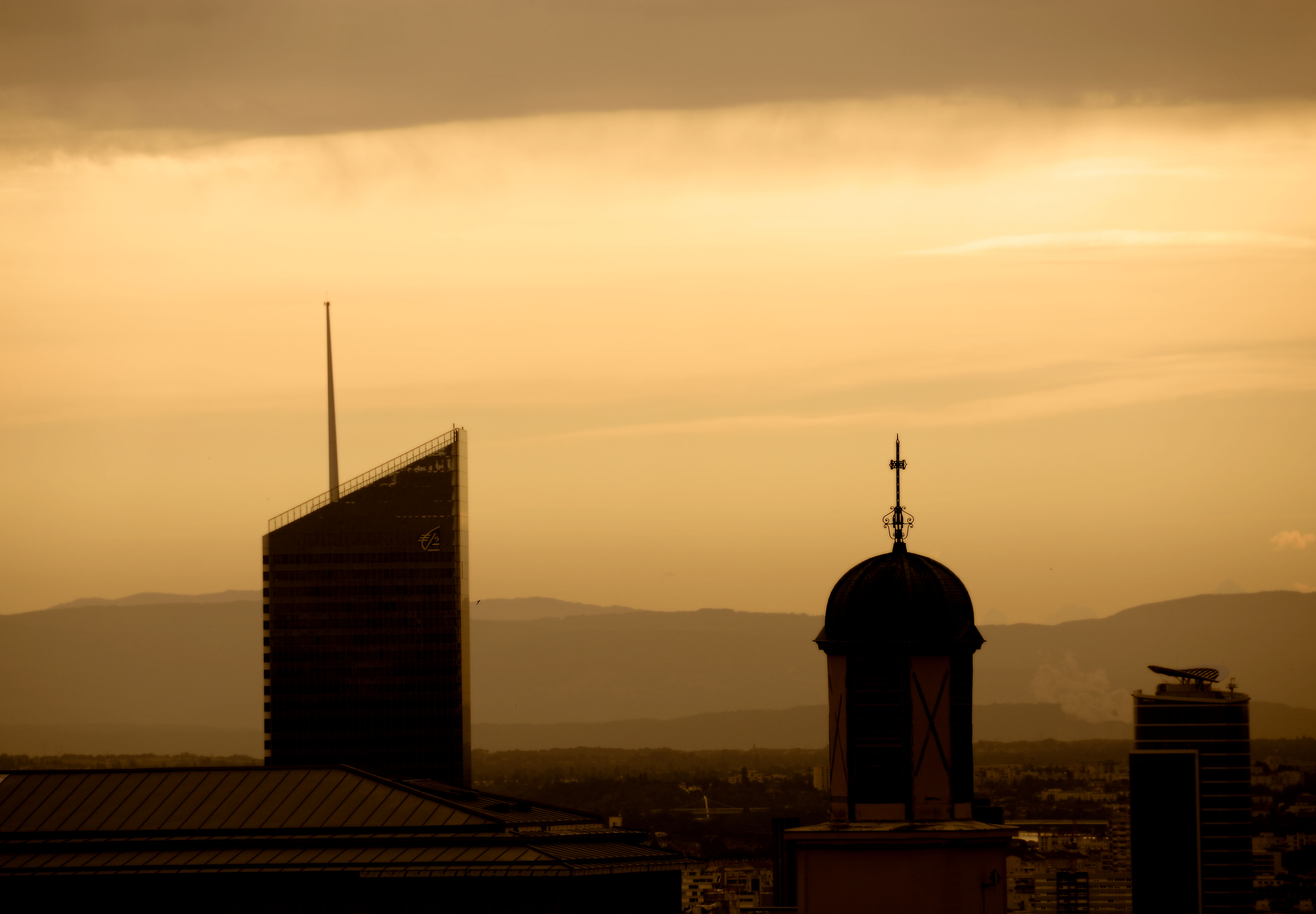 Two buildings in silhouette at sunrise