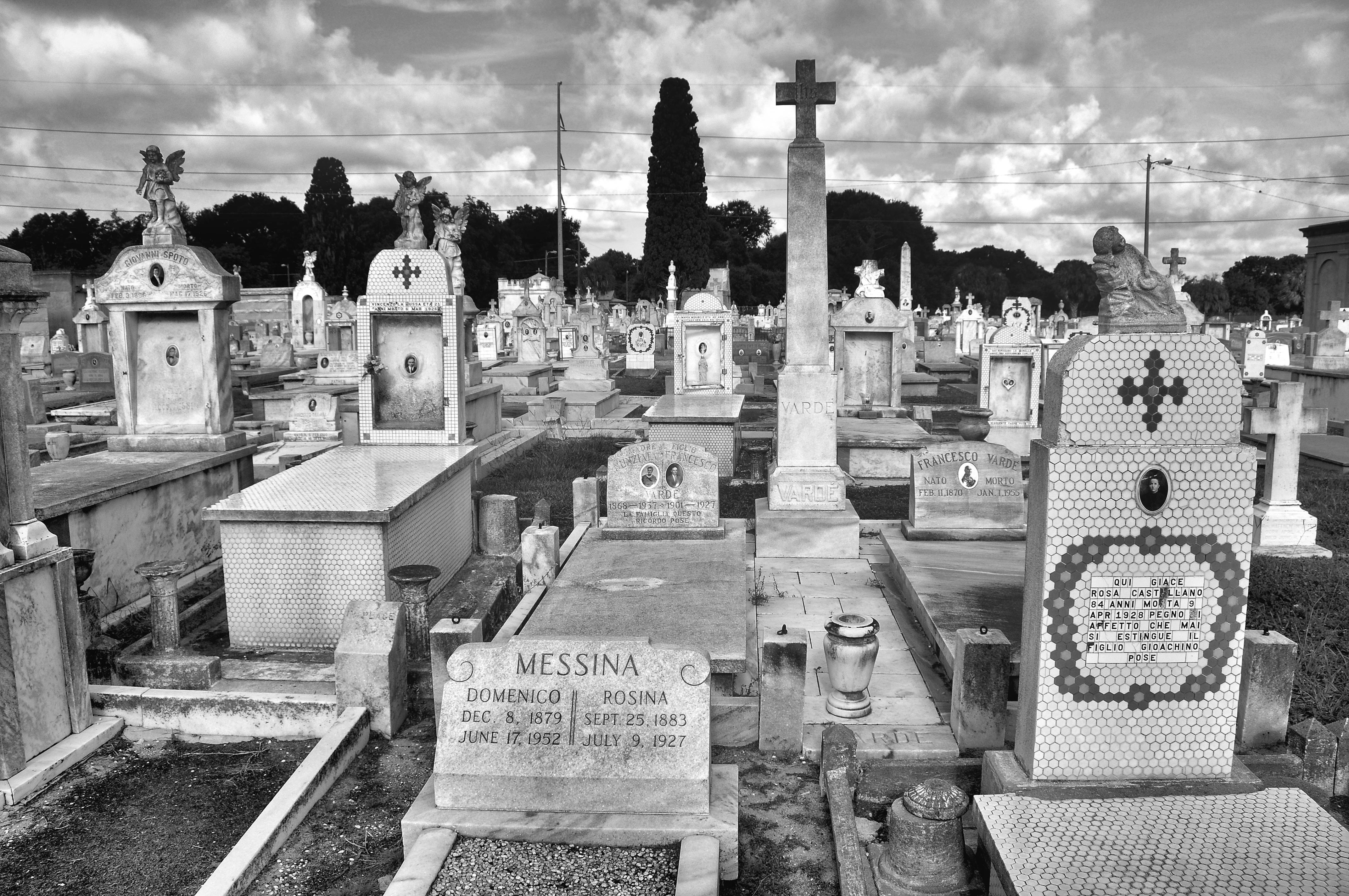 Black and white photo of historic cemetery with rows of above-ground tombs
