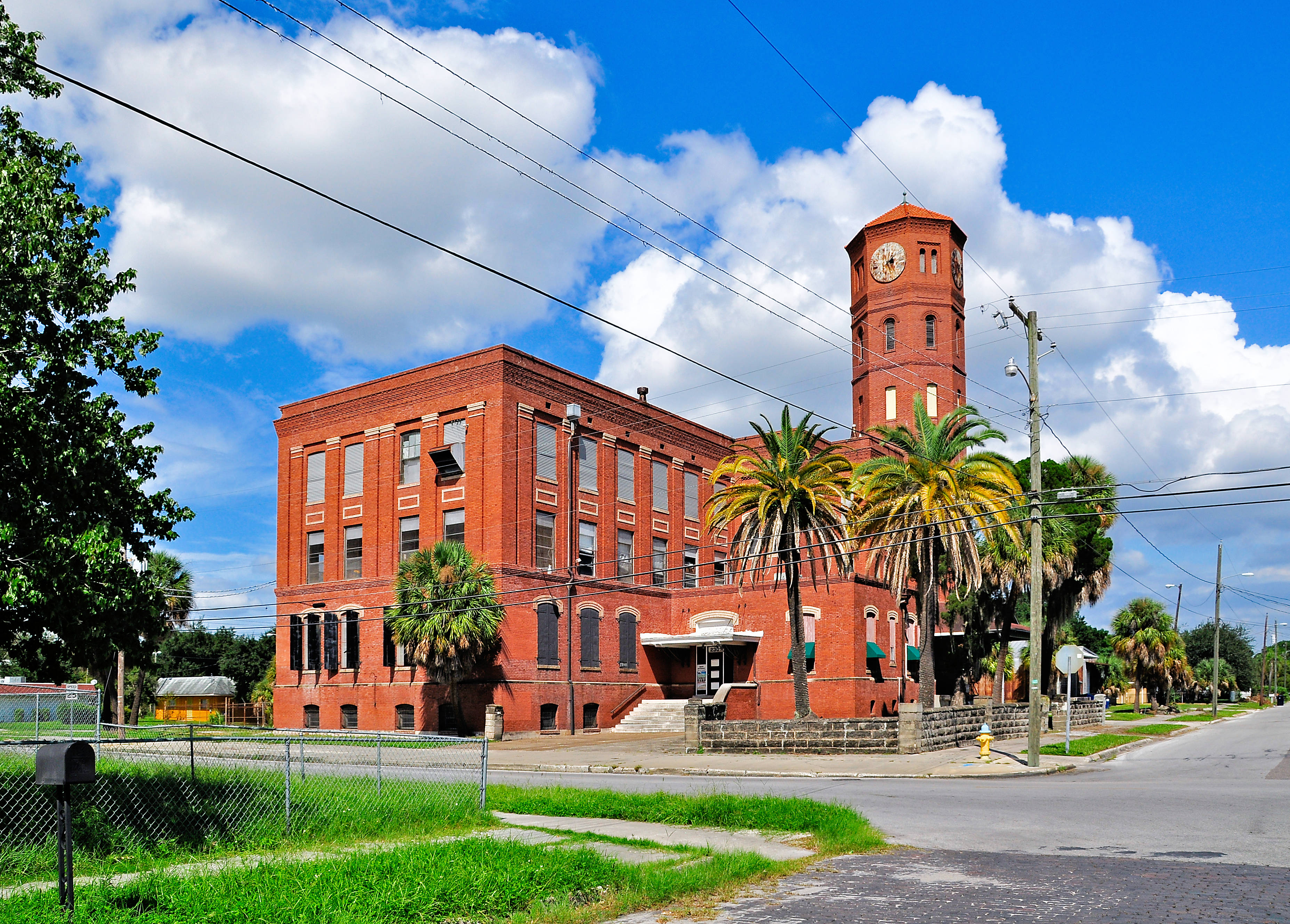 Three-story brick building with six-story brick tower near center of building
