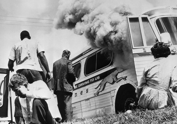 Photo of Freedom Riders outside burning bus in 1961