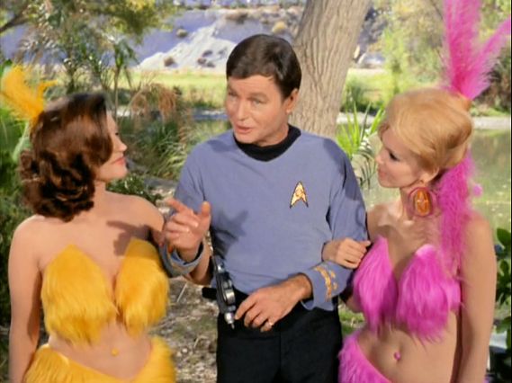 Image from Star Trek episode Shore Leave with McCoy in between two Vegas-style show girls